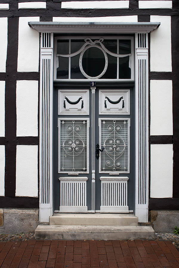 Photo 00235: Huge, panelled, carved double door in grey and white colours