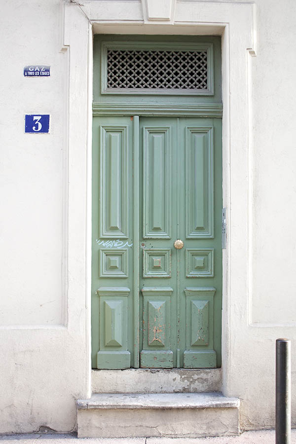 Photo 02168: Worn, panelled, light green door with grated top window