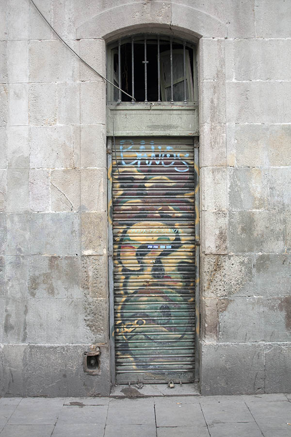 Photo 02353: Worn, brown grafittied metal security shutter and formed top window