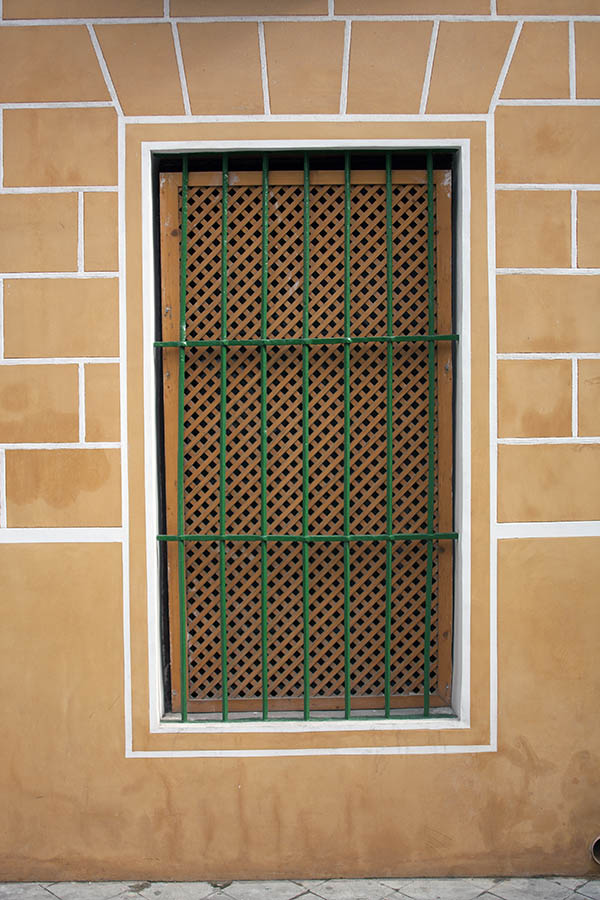 Photo 03282: Grated window on a light brown wall