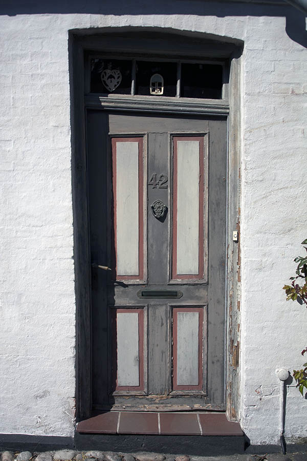 Photo 03788: Lopsided, panelled brown, grey and red door