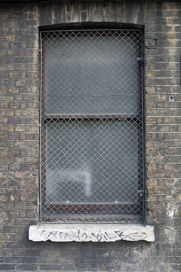 Photo 05257: Grated, oiled sash window with two panes