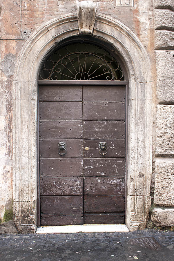 Photo 07946: Worn, brown double door made of planks with latticed fan light and pilaster