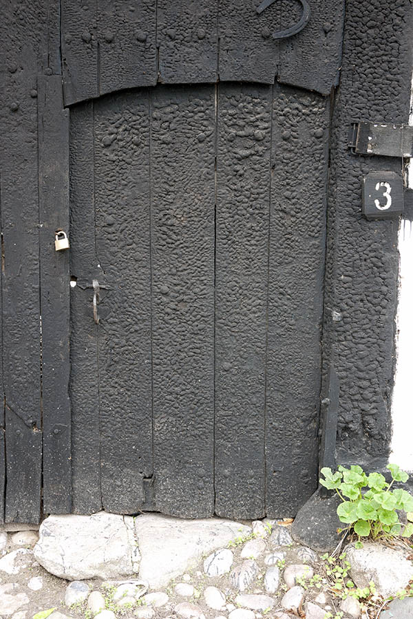 Photo 08338: Worn, formed, black door in a gate