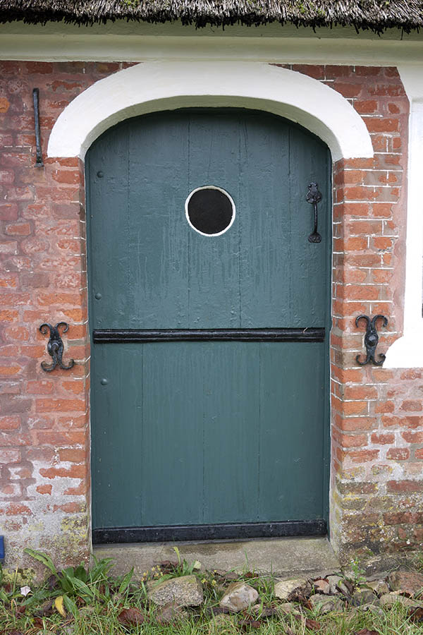 Photo 09681: Formed, teal half-door made of planks with a round door light