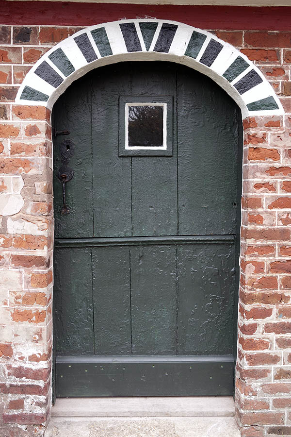 Photo 09855: Lopsided, black and white half-door made of planks with a square door light