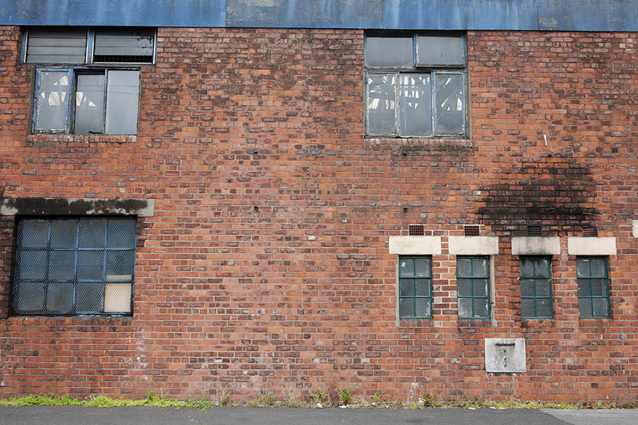 Photo 11502: Facade with red brickwork and seven worn, blue window