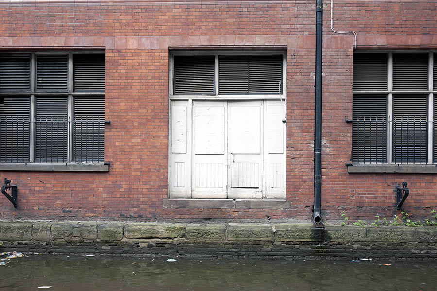Photo 11512: Facade with large, white double door and large, grated windows