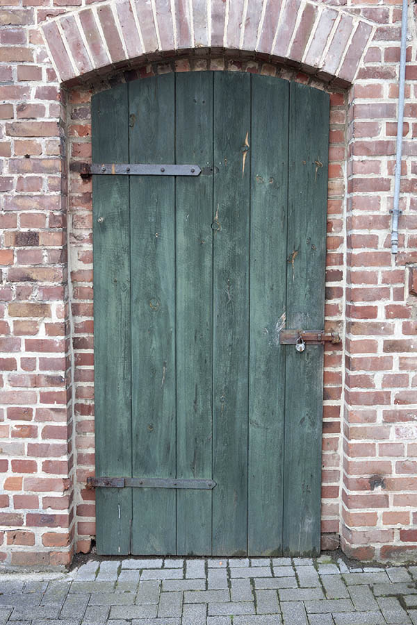 Photo 11773: Formed, green door made of planks leading to a garden