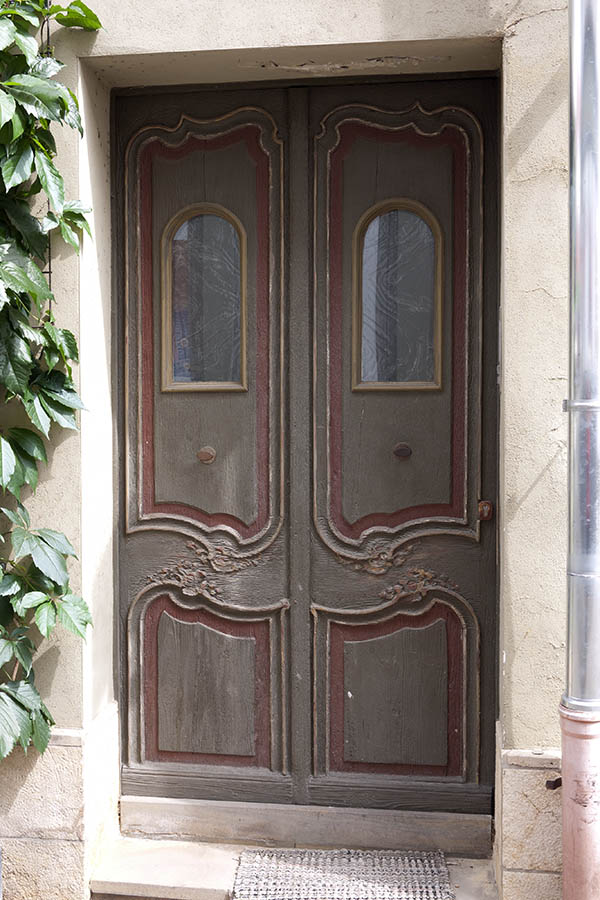 Photo 11995: Worn, carved, panelled, brown, yellow and red double door with formed door lights
