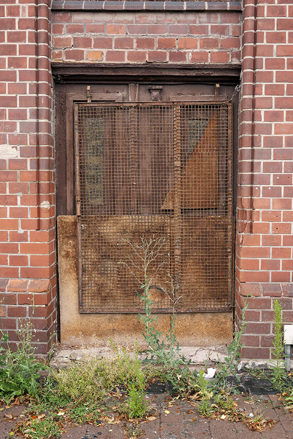 Photo 12158: Decayed, panelled, brown door with sidepiece and rusty lattice