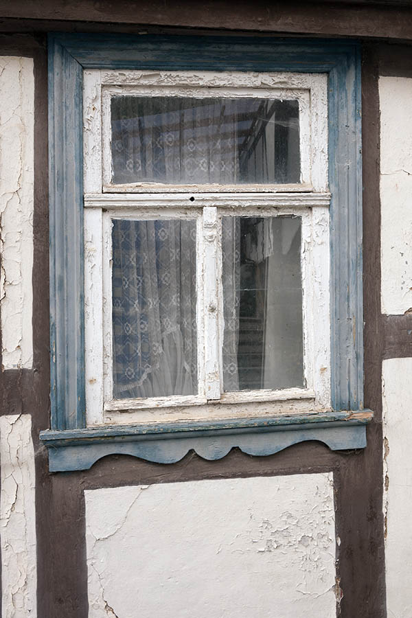 Photo 12536: Decayed, white and light blue window with three frames. .