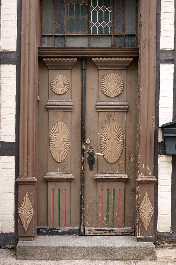 Photo 12686: Decayed, carved, panelled, brown, yellow, red and green double door with top window