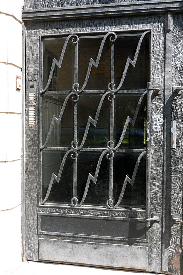 Photo 13442: Grey, hammered metal door with large door light and grating