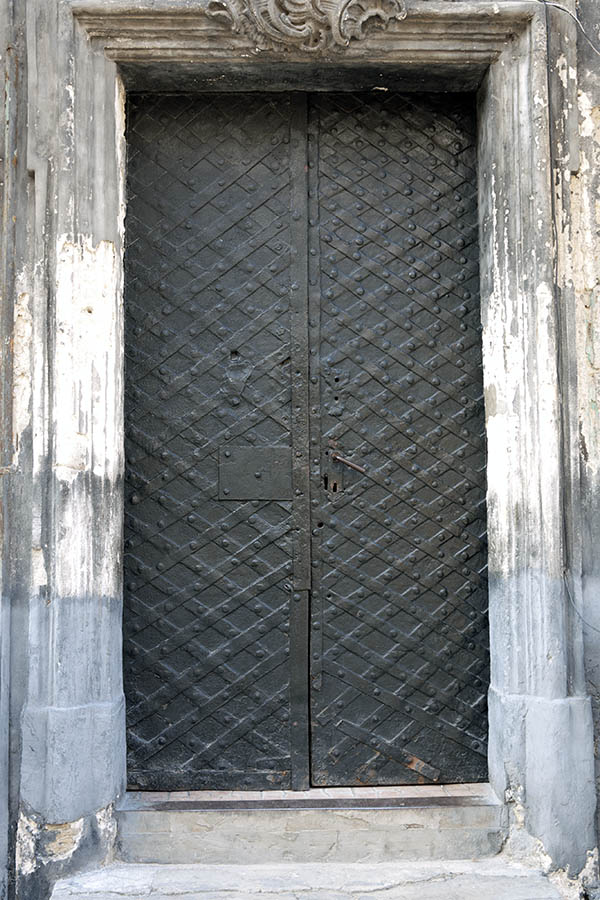 Photo 13764: Worn, black metal door with metal decoration