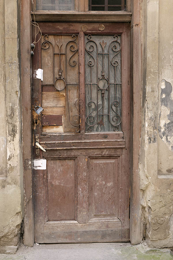 Photo 13893: Decayed, panelled, light brown door with latticed door light