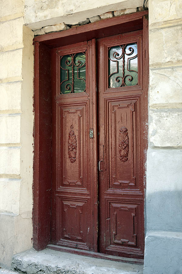 Photo 13935: Worn, carved, panelled, brown double door with latticed door lights