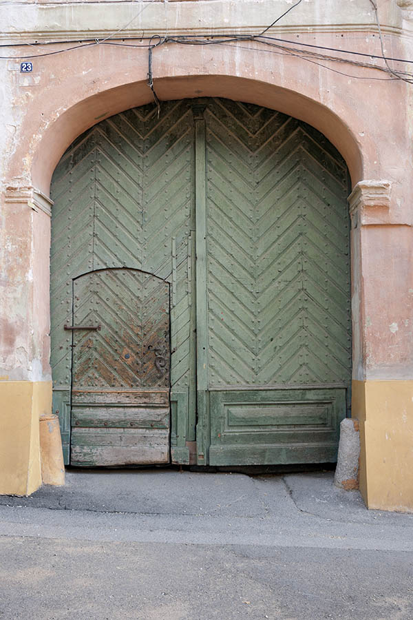 Photo 14383: Worn, panelled, formed, light green gate with minor door.