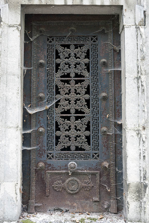 Photo 15606: Decayed, grey and rusty cast iron door with a-la-greque pattern, etc.