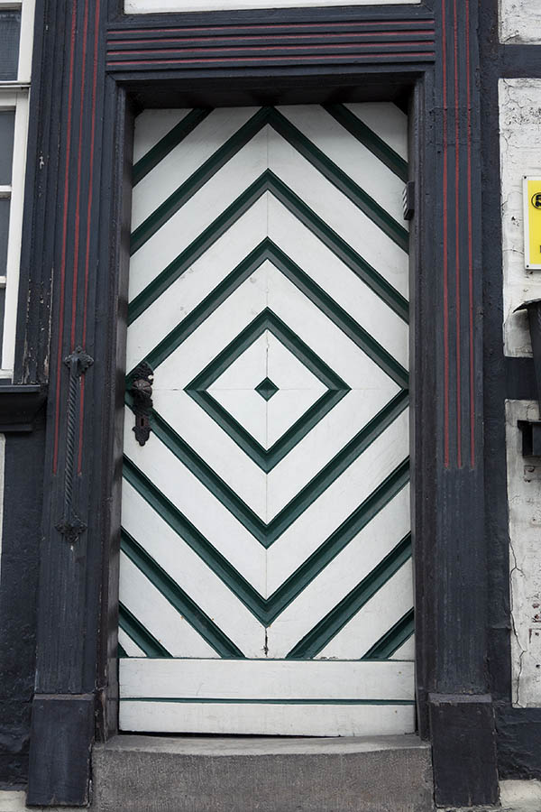 Photo 16206: White and green door made of planks within a black and red frame