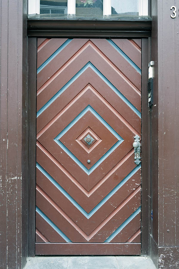 Photo 16296: Brown, blue and red door made of planks with white top window