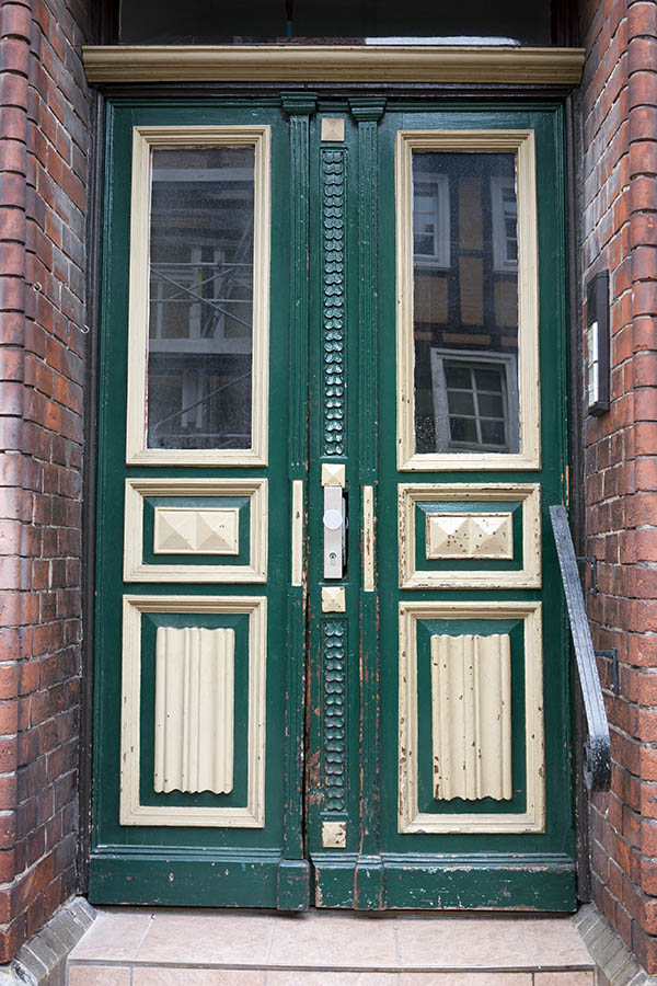 Photo 16404: Worn, panelled, carved, green and yellow double door with door lights