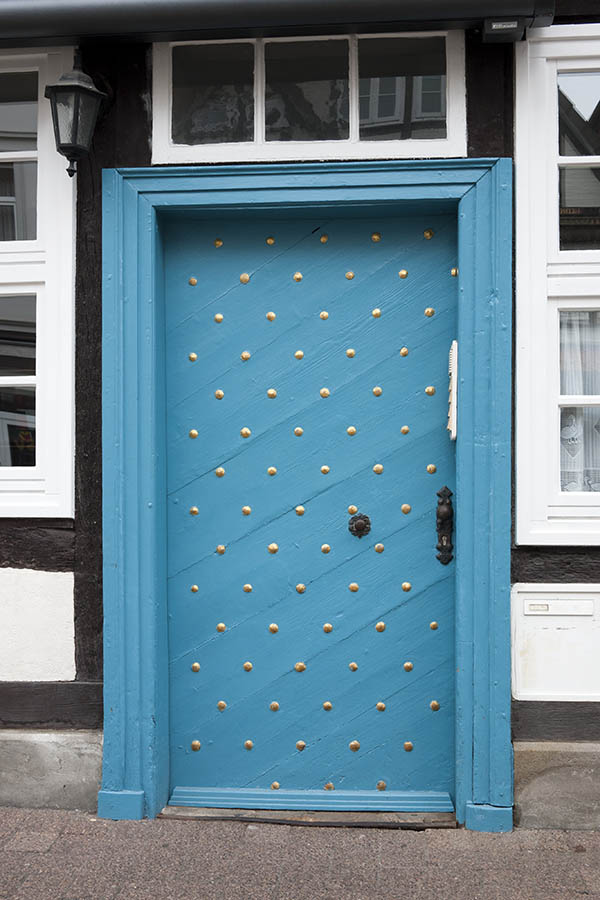 Photo 16418: Turquoise door made of planks with many nails with black and white top window