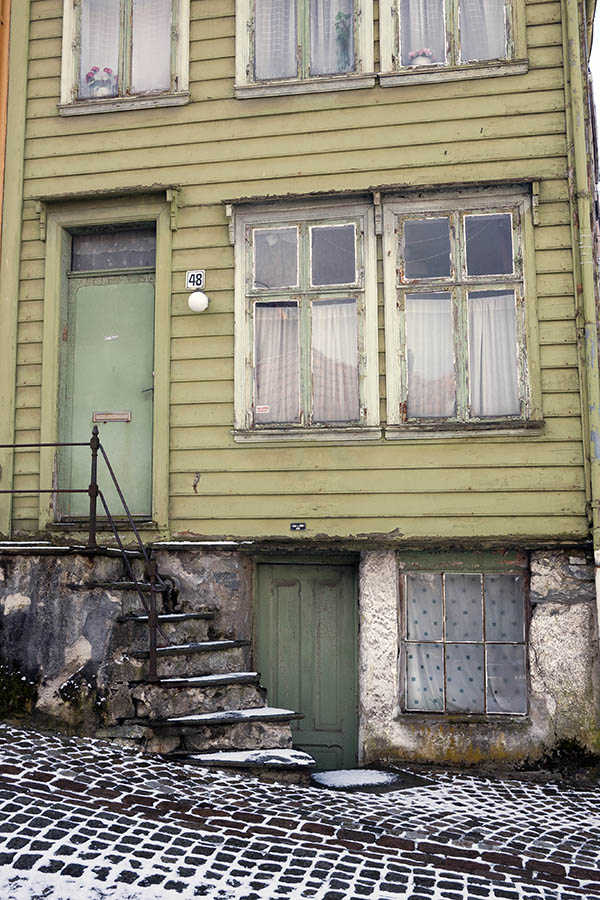Photo 16879: Worn, light green facade of board partition with green door and windows