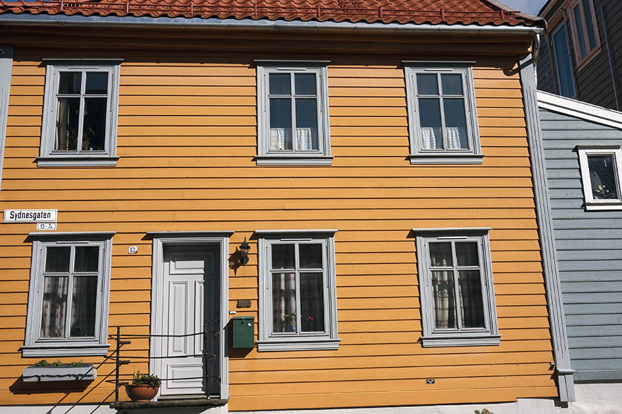 Photo 16912: Facade of yellow wooden house with a grey door and six grey windows