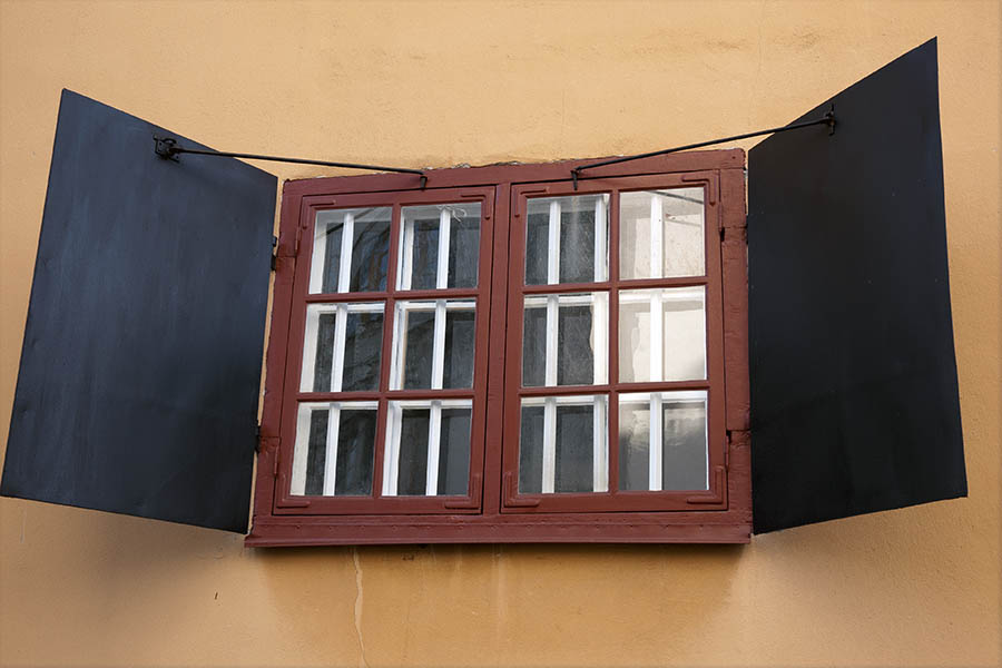 Photo 17616: Barred, red window with two frames, 12 panes and black shutters