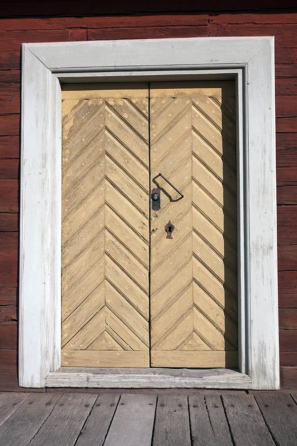 Photo 18023: Light yellow double door of diagonally mounted boards in a wide, white frame