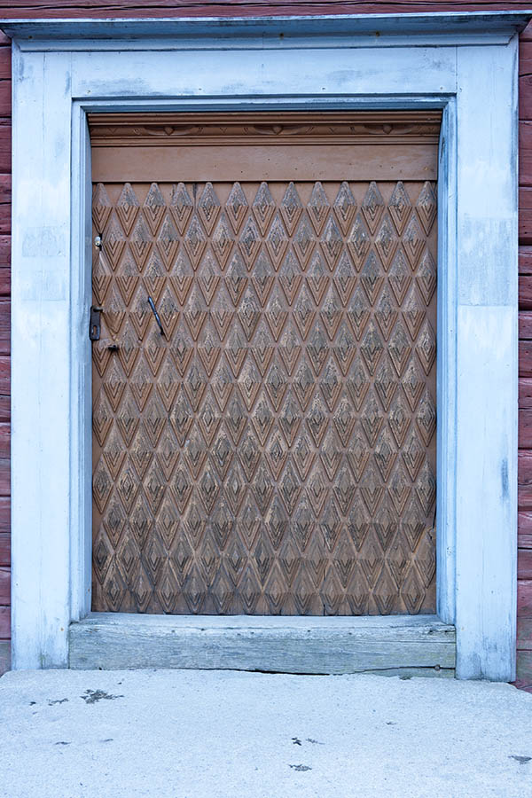 Photo 18041: Wide, brown, carved door with a very detailed pattern in a light blue frame