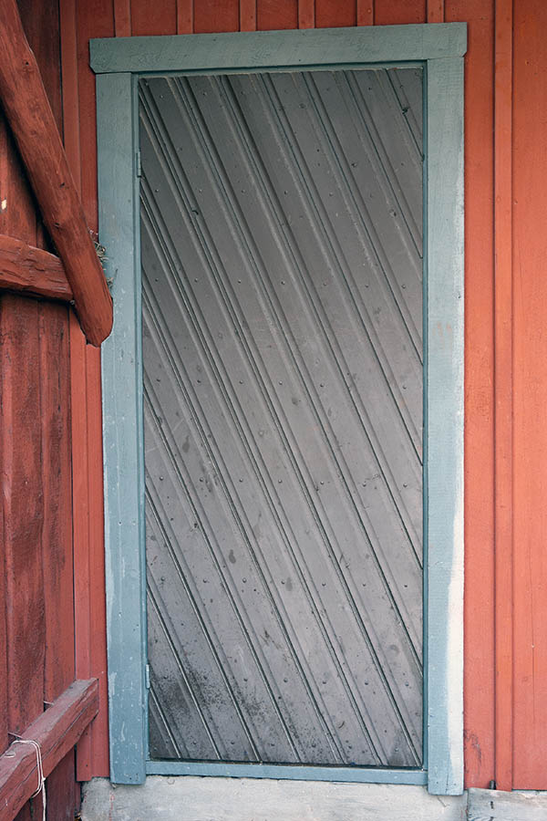 Photo 18220: Brown door of diagonal boards in a teal frame
