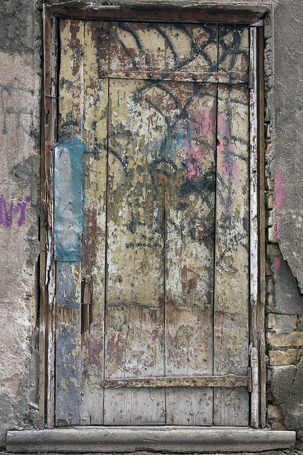 Photo 19510: Decayed, grey door of boards with many colours