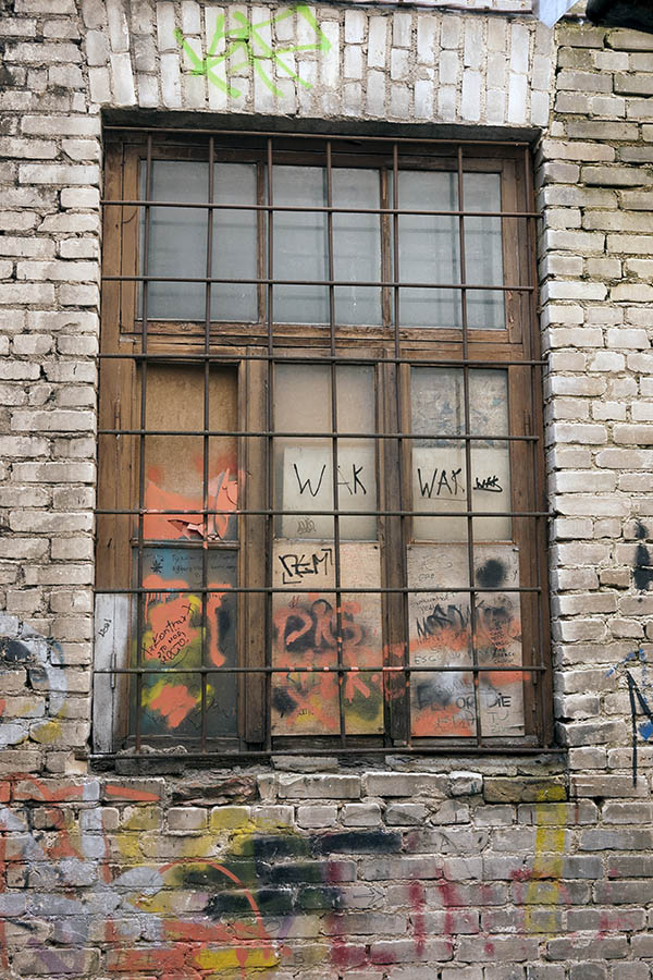 Photo 19516: Decayed, barred, brown window with four frames and nine panes