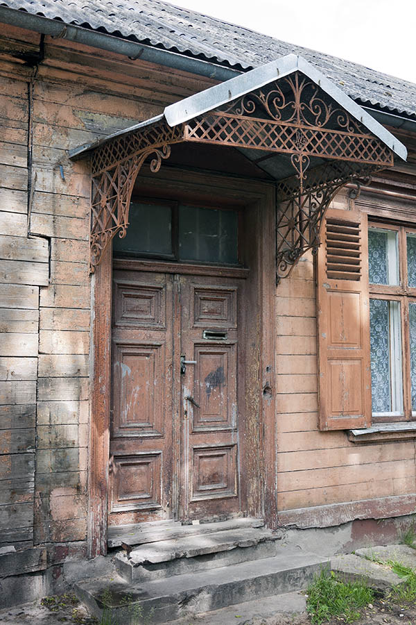 Photo 19753: Worn, panelled, light brown double door with top window and metal, orange windbreak
