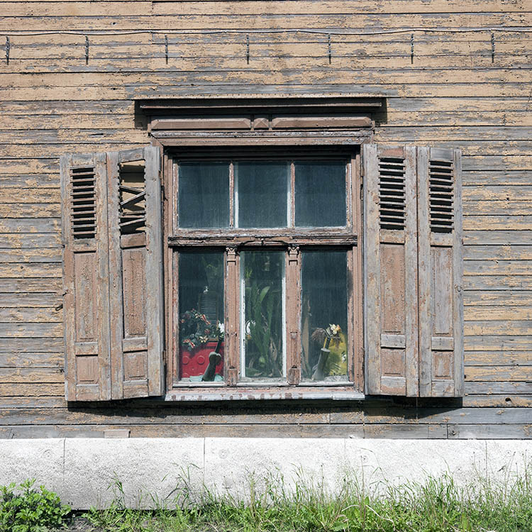 Photo 19804: Worn, light brown window with four frames, six panes and decayed shutters