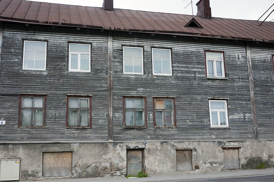 Photo 20116: Facade with worn, black board partition and brown and white windows