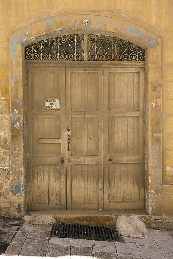 Photo 24114: Worn, panelled, yellow garage door with latticed fan light
