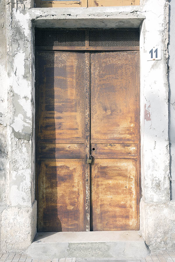 Photo 24440: Worn, rusty, brown double door and latticed top window