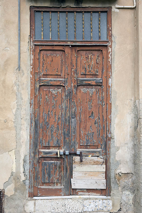 Photo 24463: Panelled, carved, decayed red double door with barred top window