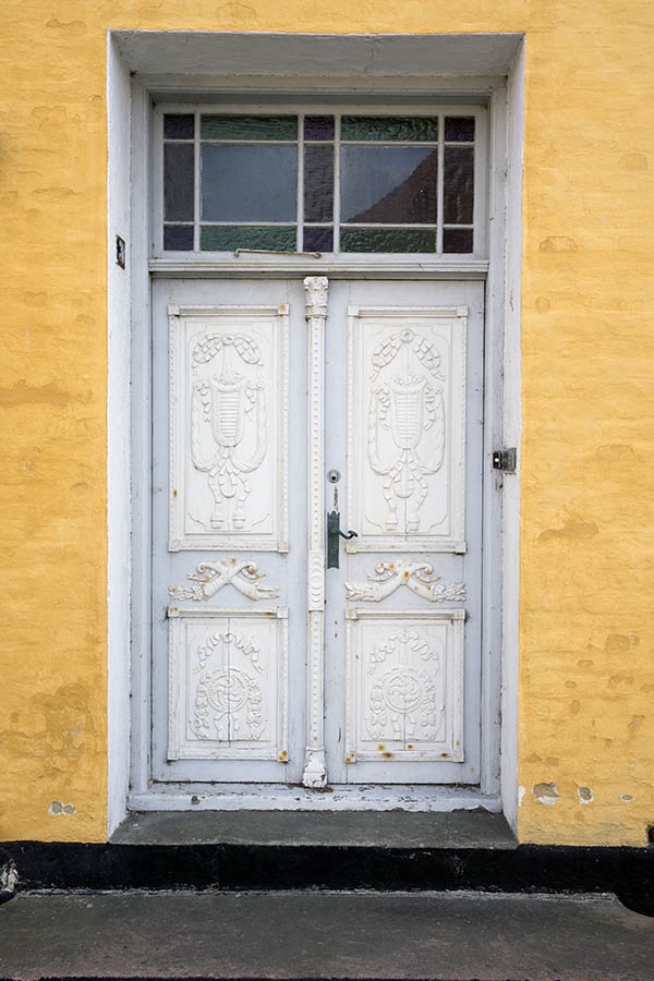 Photo 25243: Worn, panelled, grey and white double door with carved panels and top window with coloured glass