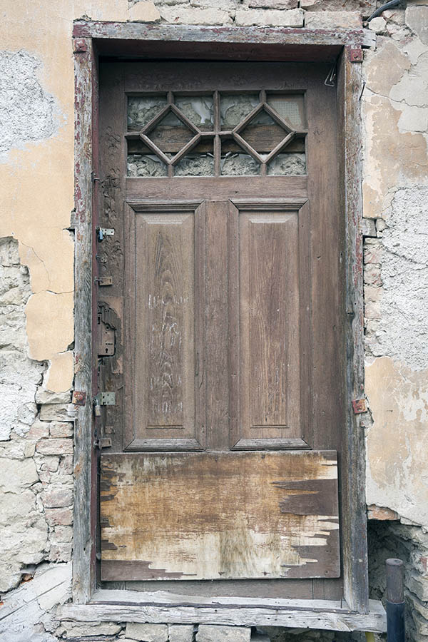 Photo 25403: No door. A former, decayed, brown, panelled door in a decayed wall