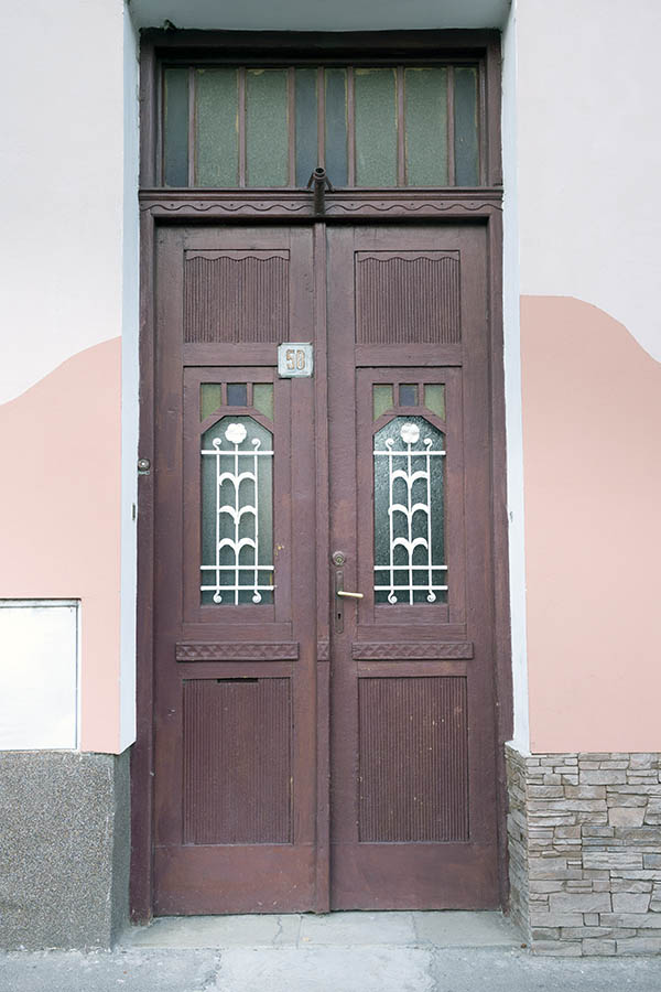 Photo 25656: Narrow, panelled, carved, brown double door with latticed fan light and top window