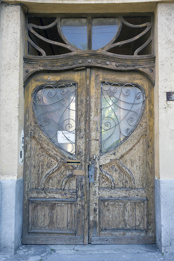 Photo 25690: Decayed, panelled, yellow and unpainted double door with latticed door light and top window