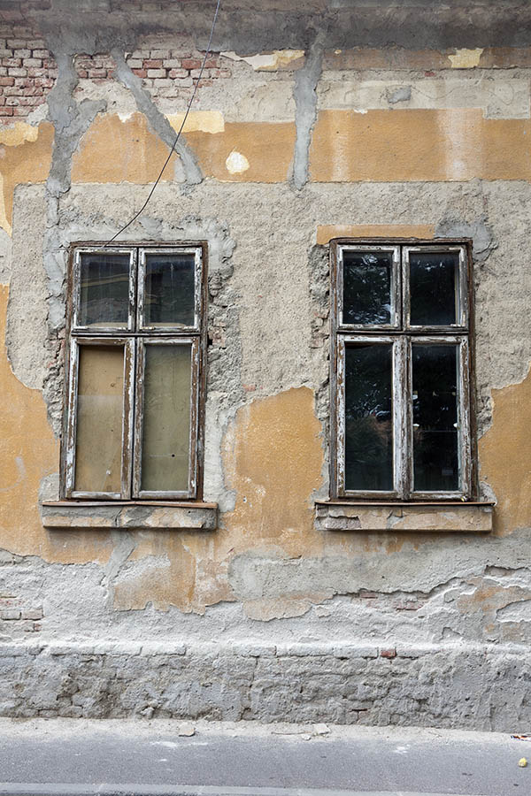 Photo 25759: Facade with two worn, brown and white windows with four frames each