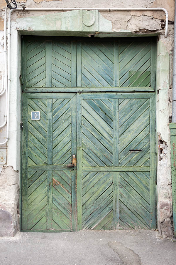 Photo 25760: Worn, panelled, light green gate with diagonal boards and minor door