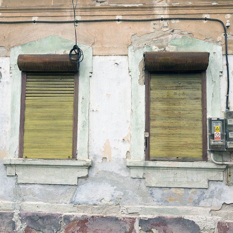 Photo 25761: Facade with two windows covered by yellow and brown security shutters