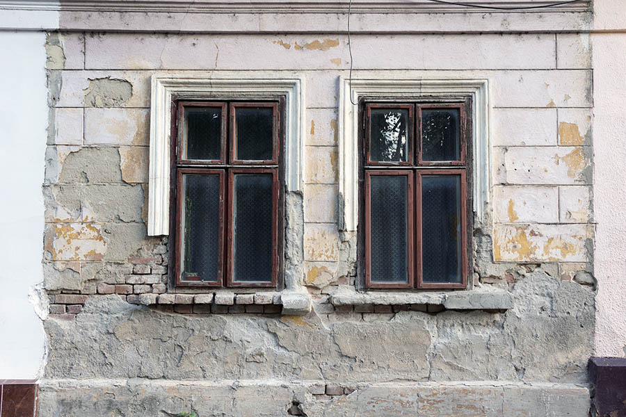 Photo 25812: Worn facade with two brown window with four frames each