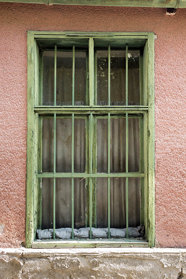 Photo 25995: Worn, barred, green window with four frames and six panes